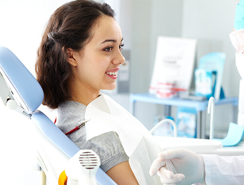Young woman sitting in the dental chair 